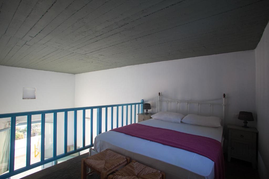 a bedroom with a bed and a balcony at Oliaros seaside complex in Agios Georgios