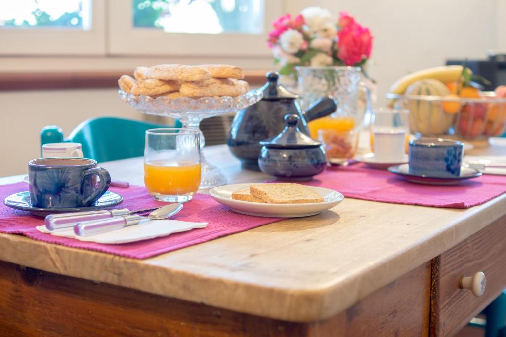 un tavolo con biscotti e una ciotola di succo d'arancia di B&B Salighes a Ozieri