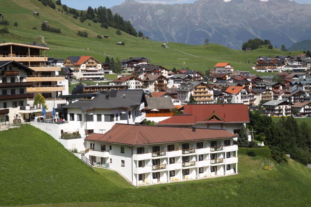 a town on a hill with houses and mountains at Hotel Bärolina in Serfaus