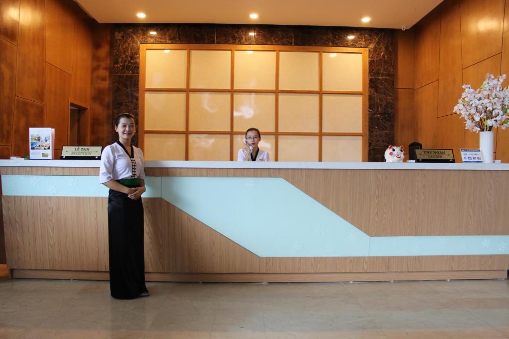 una mujer parada frente a un mostrador de recepción en Muong Thanh Cua Dong Hotel en Vinh
