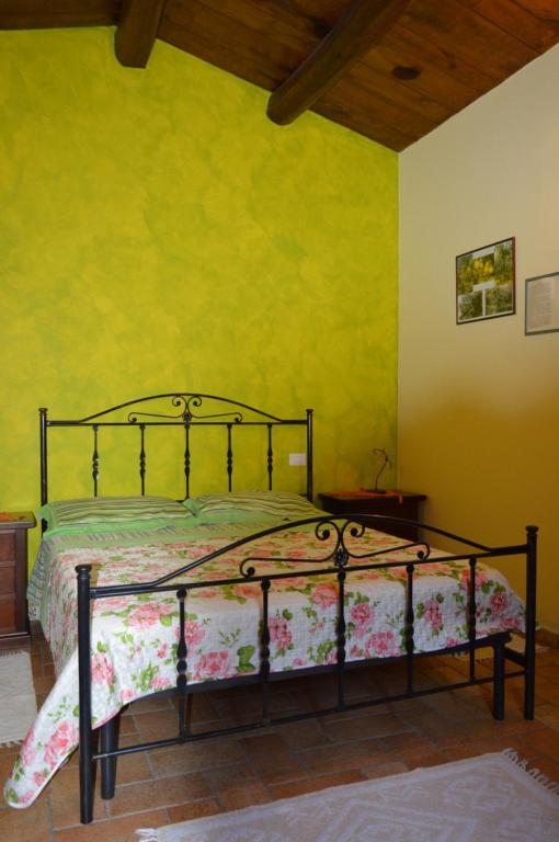 sypialnia z łóżkiem w pokoju z żółtymi ścianami w obiekcie Agriturismo E Turre w mieście Serrastretta