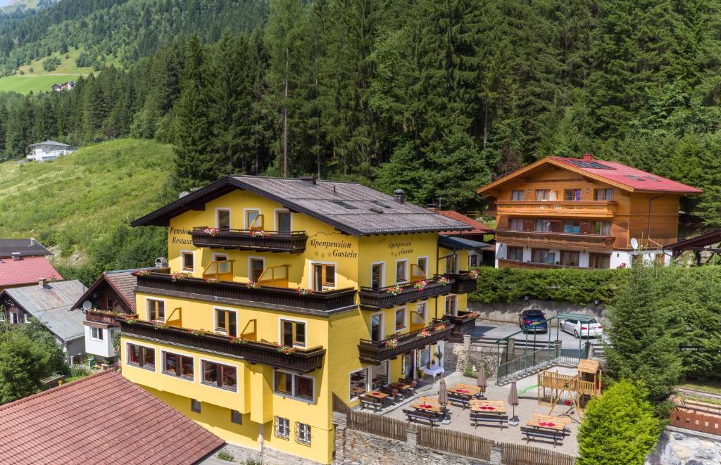 ein gelbes Haus mit schwarzem Dach in der Unterkunft Alpenpension Gastein in Bad Gastein