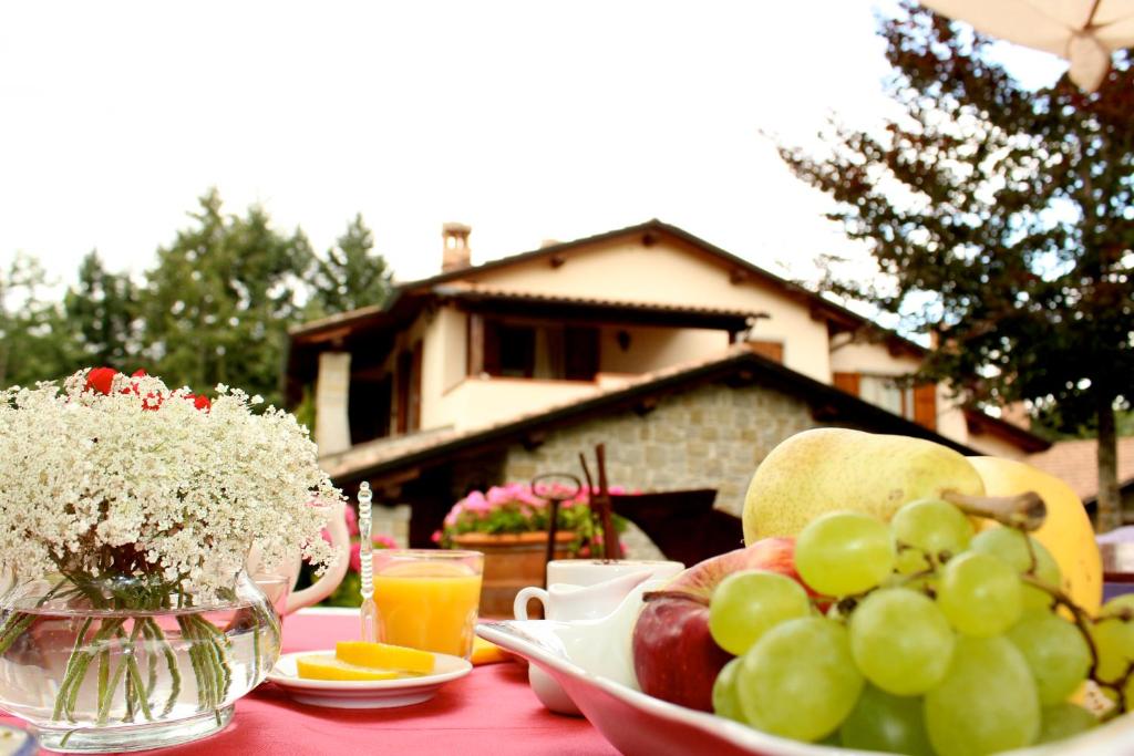 una mesa cubierta con un tazón de uvas y naranjas en Borgo Caiano Country Inn, en Caiano