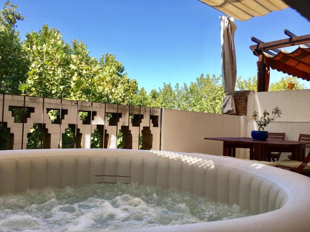 una bañera de hidromasaje en un patio trasero con una valla en TYP Sevilla, en Sevilla
