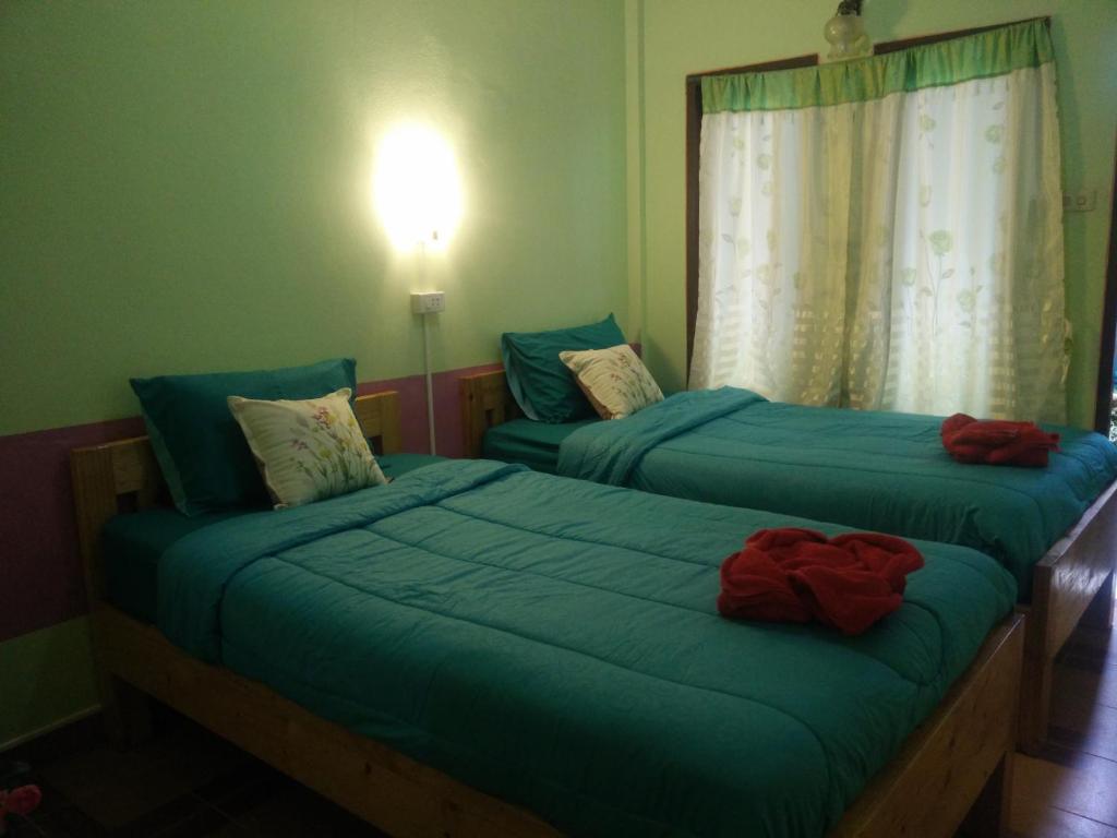2 Einzelbetten in einem Zimmer mit Fenster in der Unterkunft Samed Thanee in Ko Samed