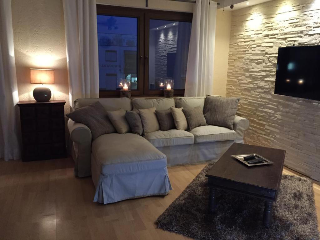 ein Wohnzimmer mit einem Sofa und einem TV in der Unterkunft Appartement St. Barbara in Trier