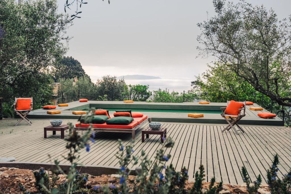 a patio with a couch and chairs and a pool at Borgo degli Ulivi in Porto Ercole