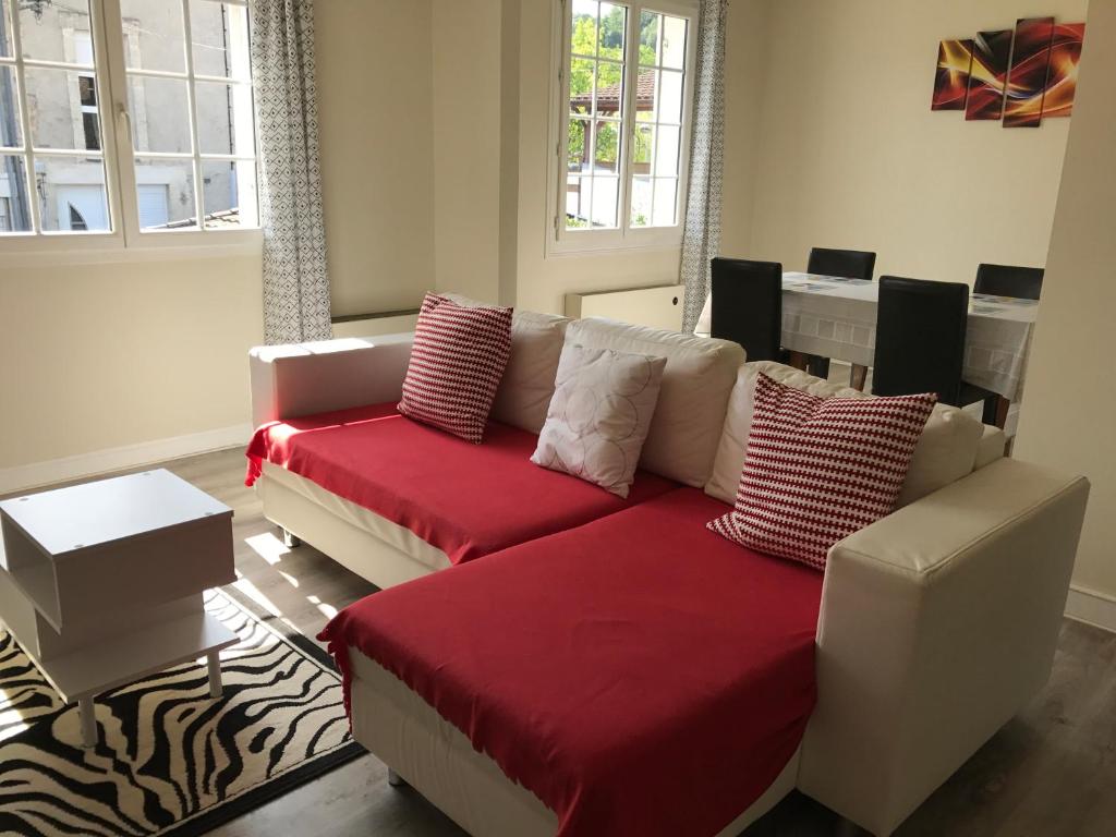 a living room with a red couch with pillows at Good Place in Périgueux