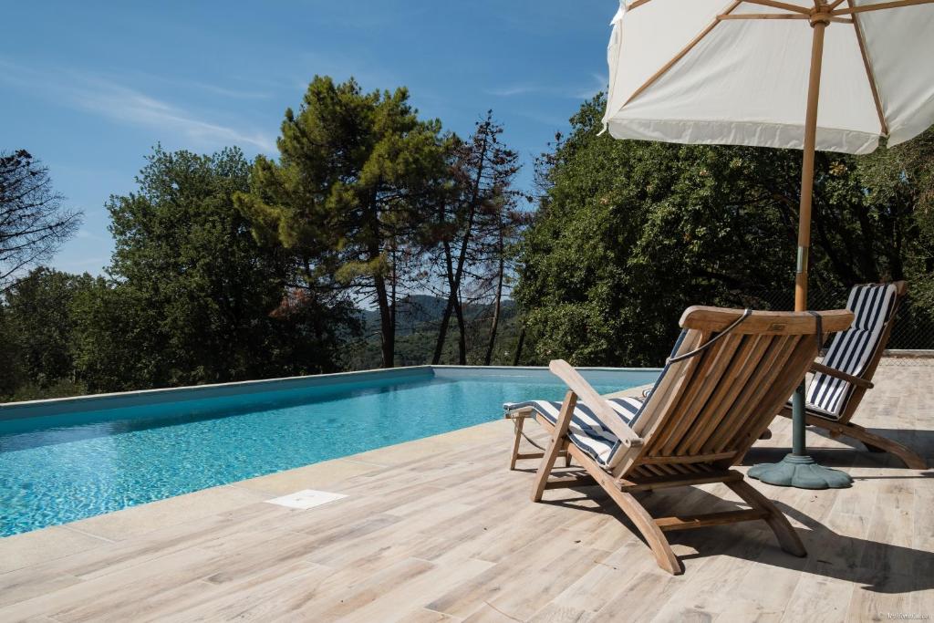 una sedia e un ombrellone accanto alla piscina di The Blue Villa a Lucca