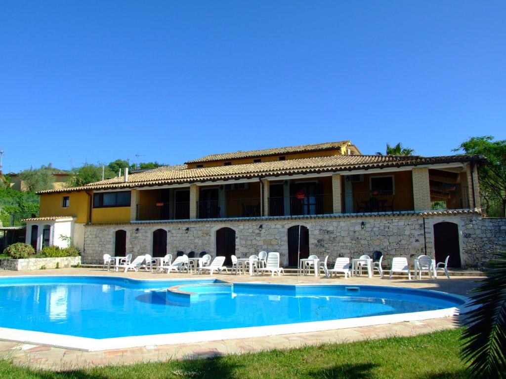 a swimming pool in front of a building at Agriturismo Le Chiuse in Carlentini