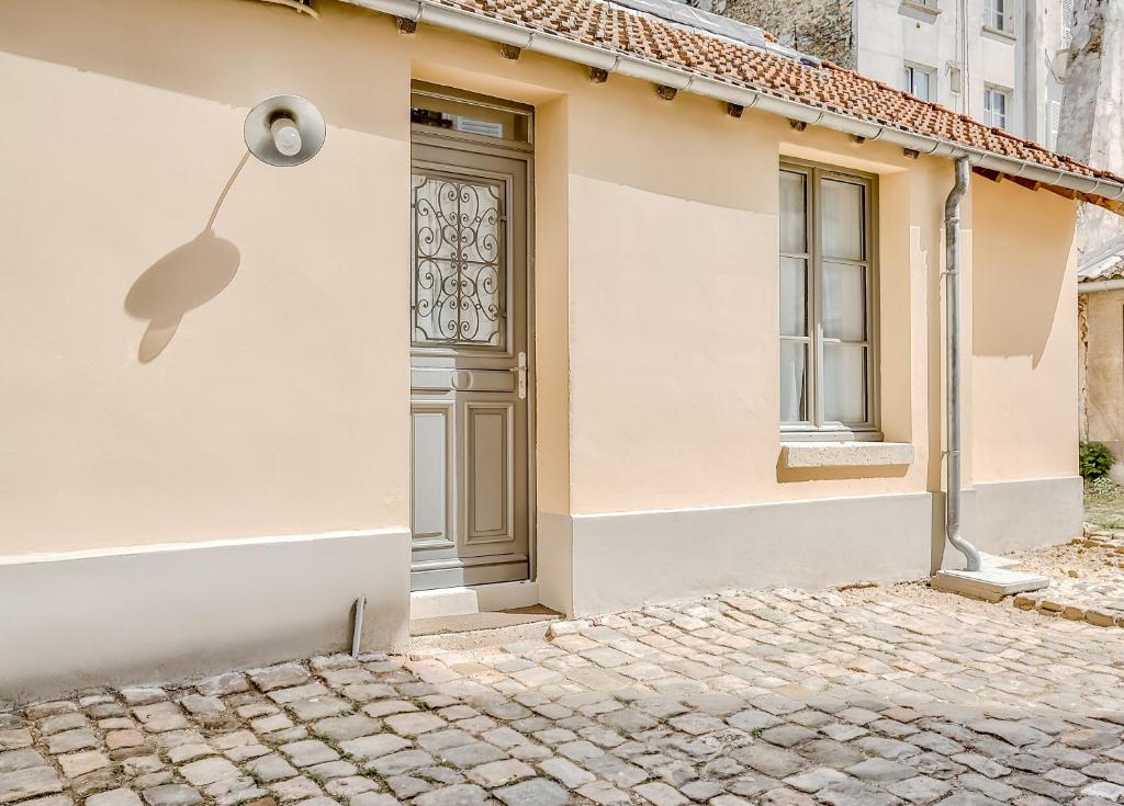 uma porta ao lado de uma casa em Le Petit Pavillon de Versailles em Versalhes