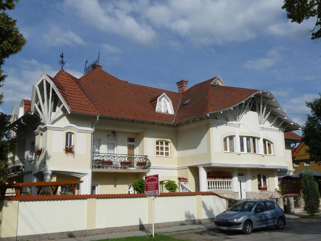 a large white house with a red roof at Apartmanház Sipos Siófok in Siófok