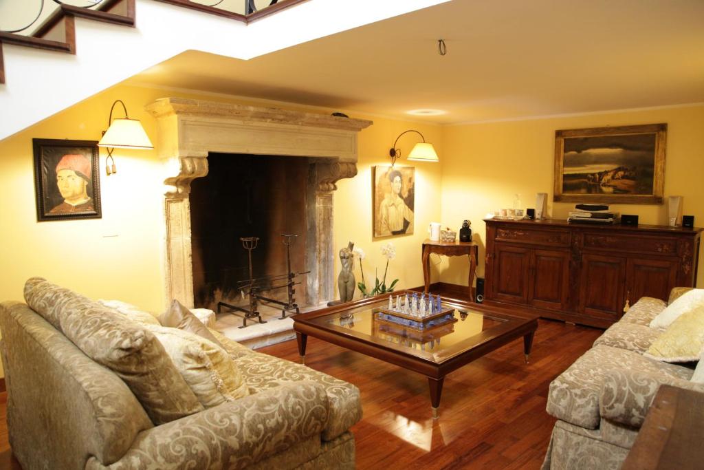 a living room with two couches and a fireplace at B&B Charme Celestino V° in LʼAquila