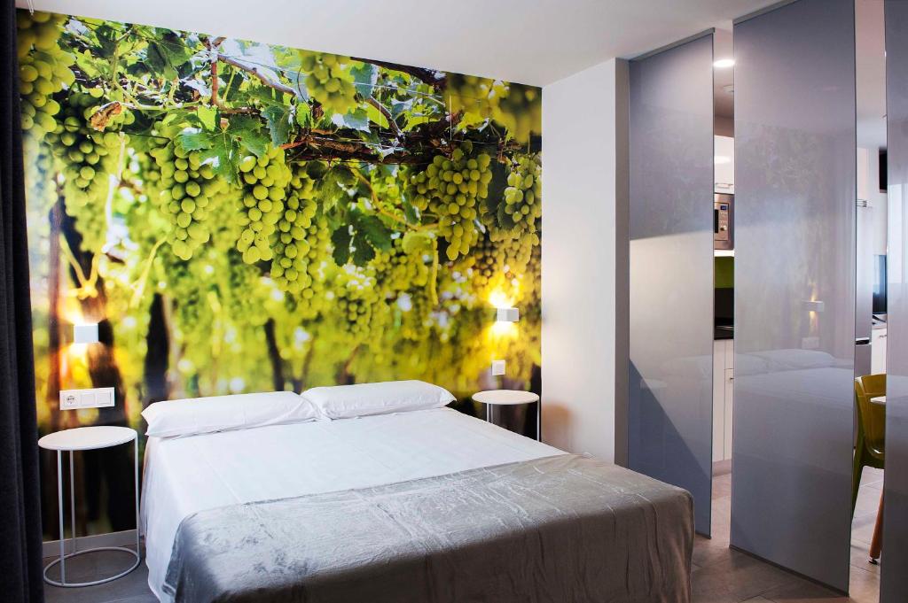 - une chambre avec un lit et une peinture de raisins dans l'établissement Apartamentos Divan, à Vitoria-Gasteiz