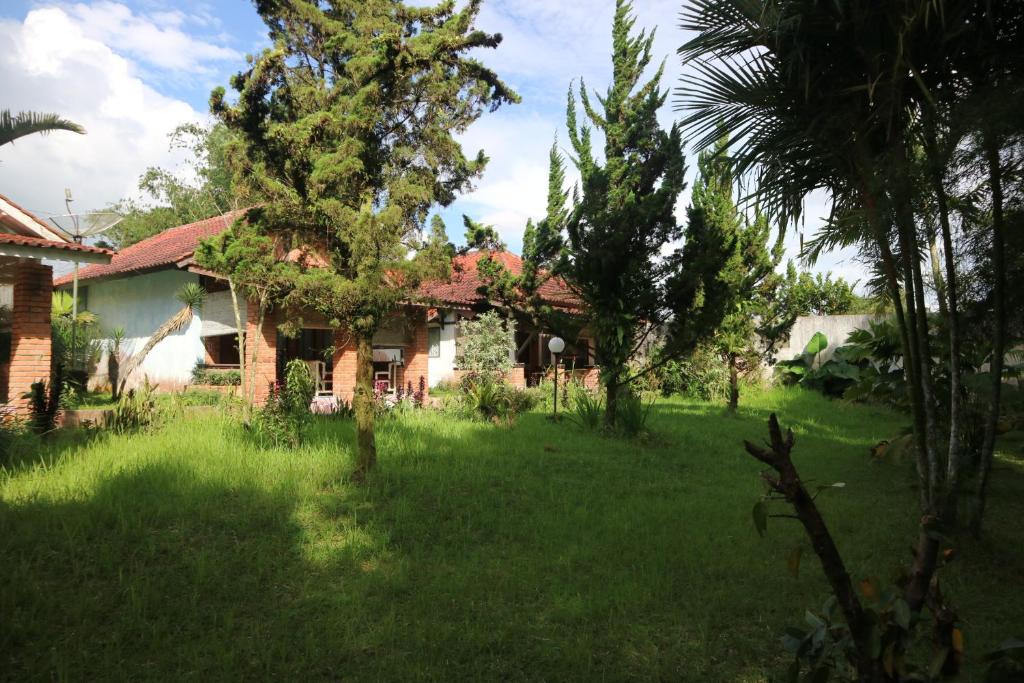 une maison dans une cour avec de l'herbe et des arbres dans l'établissement Princess Cottages, à Sukabumi