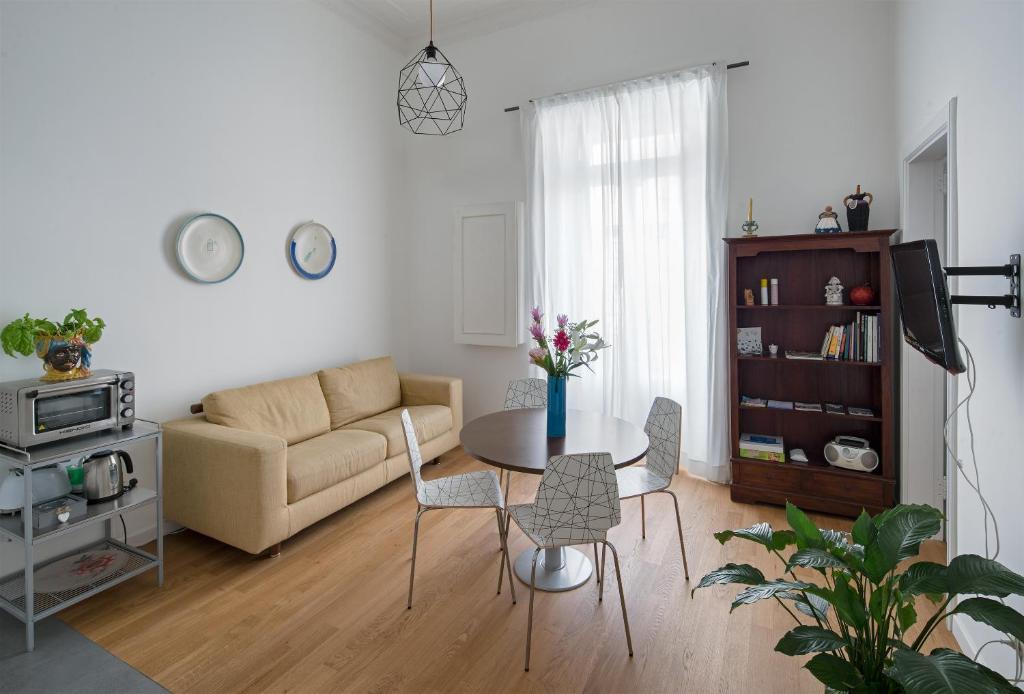 sala de estar con sofá, mesa y sillas en A Casa di Adri, en Salerno