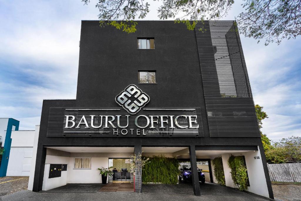 Bauru Office Hotel في باورو: مبنى اسود مع لافته للفندق