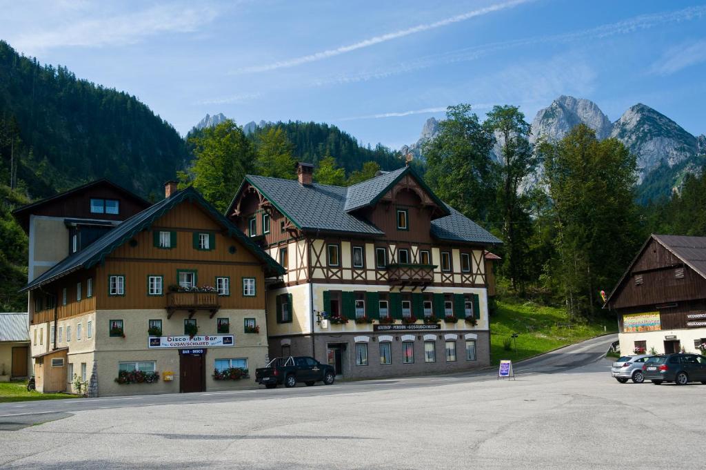 un gran edificio con coches estacionados frente a él en Jugendgästehaus Gosauschmied en Gosau