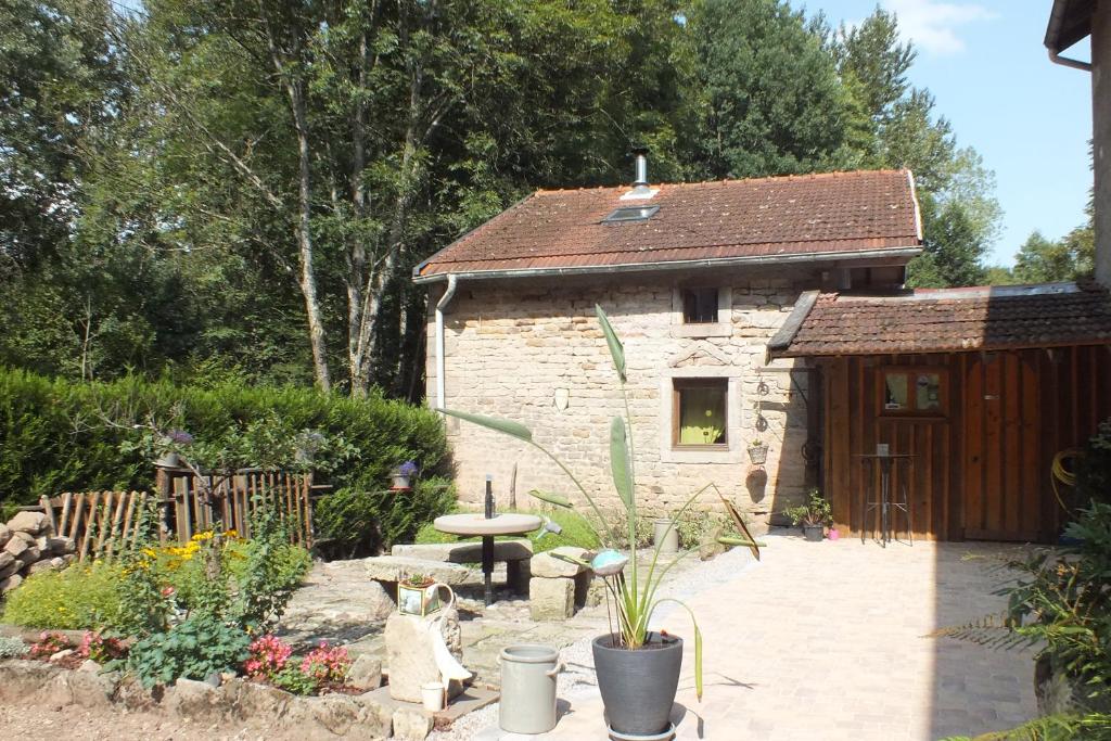 a stone cottage with a garden and a patio at La Bergerie in Xertigny