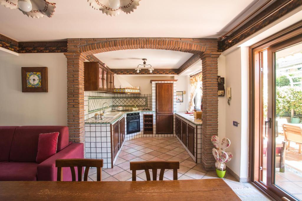 a living room with a couch and a kitchen at Sicilian Home in Aci Castello