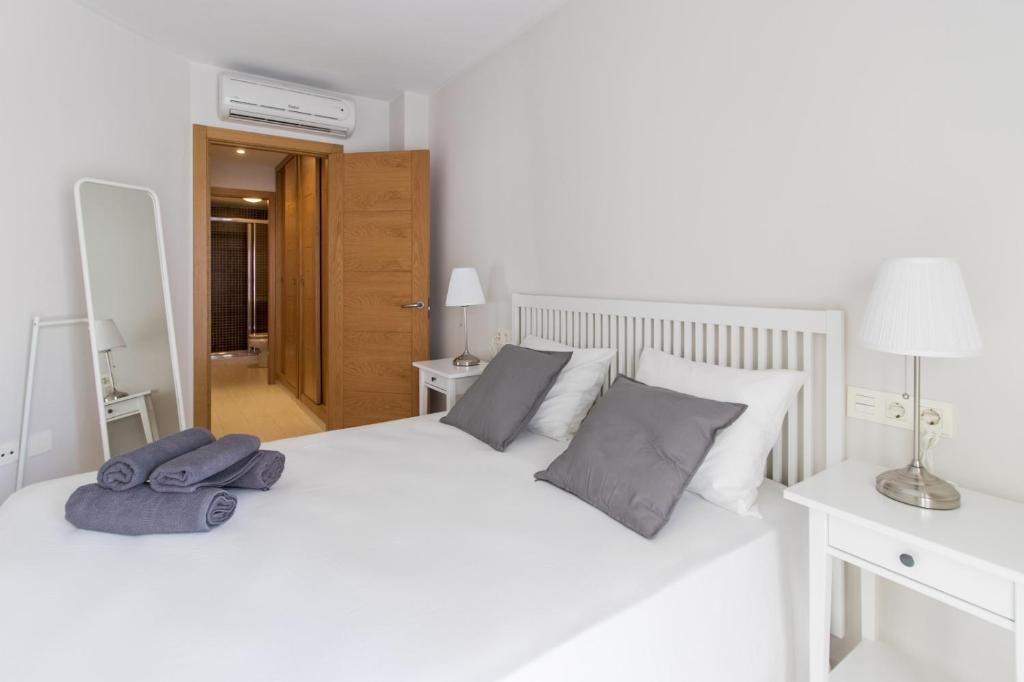 una camera da letto con un letto bianco con due asciugamani di ConMdeMálaga San Quintin a Málaga