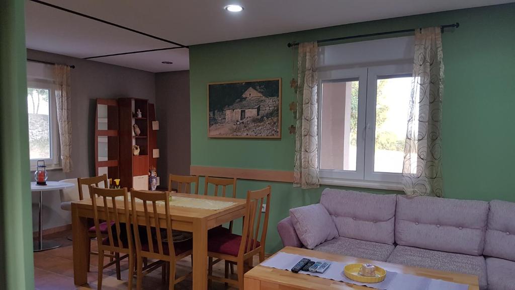 ein Wohnzimmer mit einem Sofa und einem Tisch in der Unterkunft Mountain Cottage Paradise in Mostar