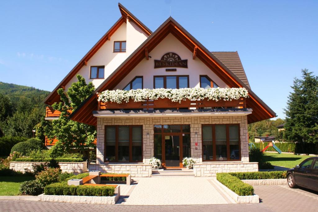 dom z kwiatami na przodzie w obiekcie Beskidian w Węgierskiej Górce