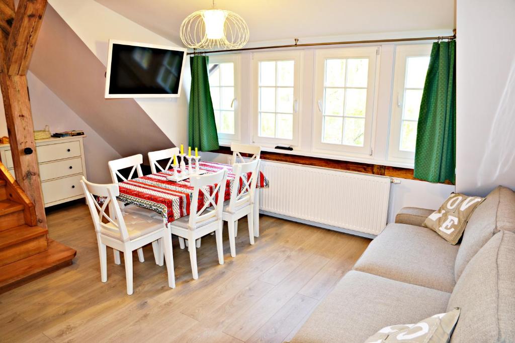 a dining room with a table and a couch at Loft Apartments by Grand Apartments in Sopot