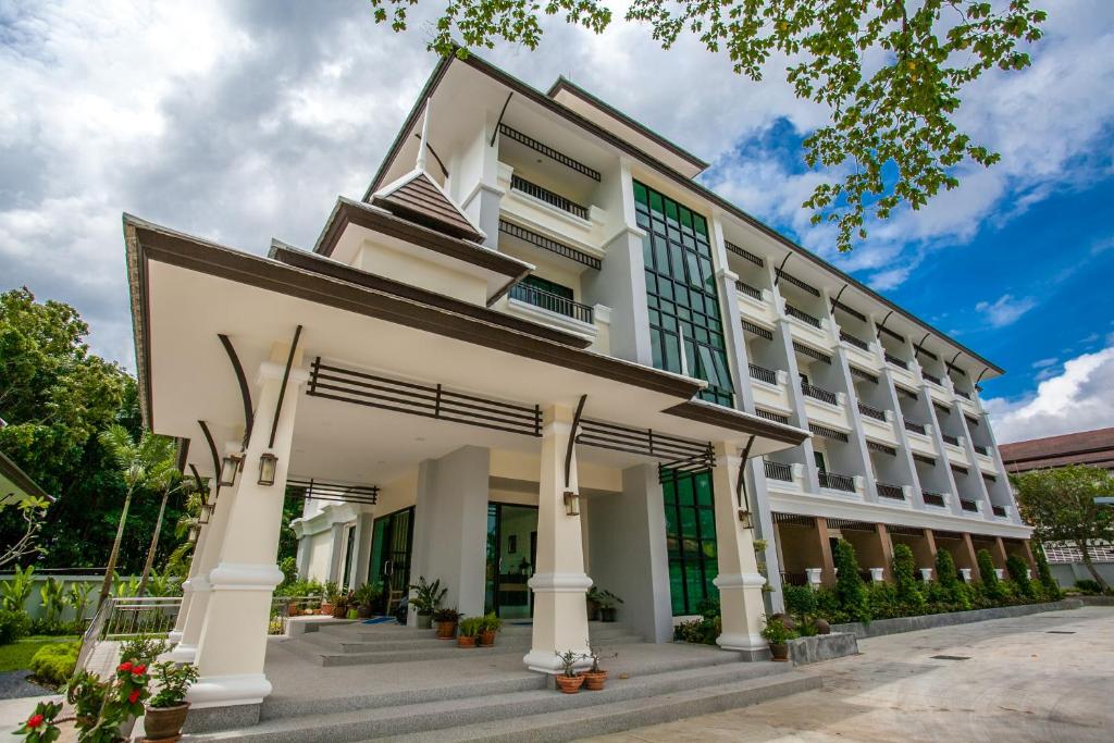 een groot wit gebouw met grote ramen bij Wanarom Residence Hotel in Krabi town