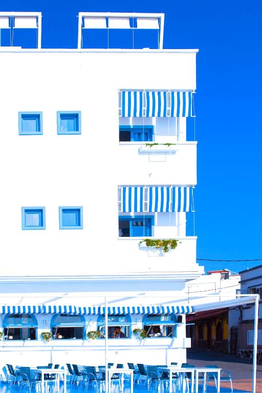 a white building with tables and chairs in front of it at AVANTI Lifestyle Hotel - Only Adults in Corralejo