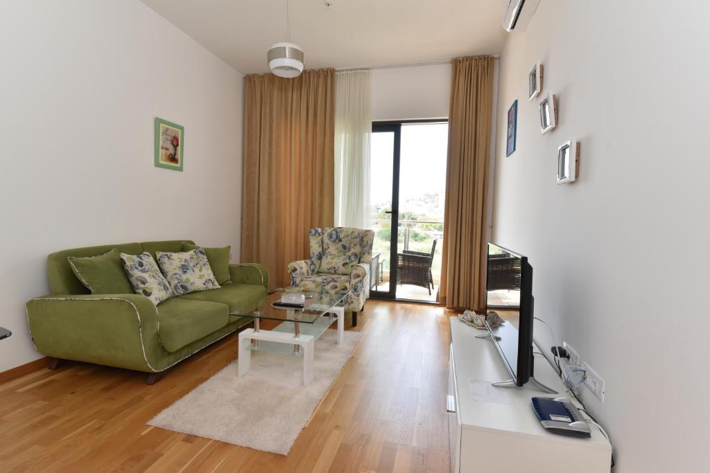 a living room with a green couch and a table at Lux Apartments Kristina in Budva
