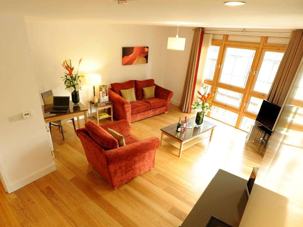 a living room with two red chairs and a table at PREMIER SUITES Bristol Cabot in Bristol