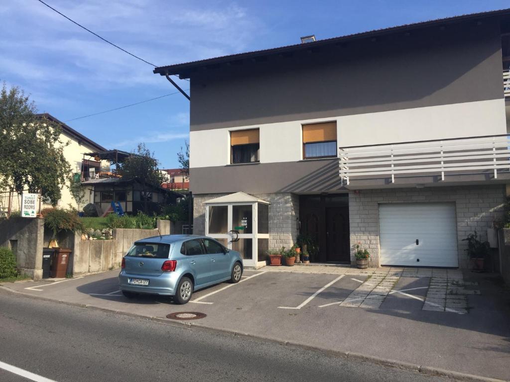 a car parked in a parking lot in front of a building at Tourist Rooms Sajovic in Postojna