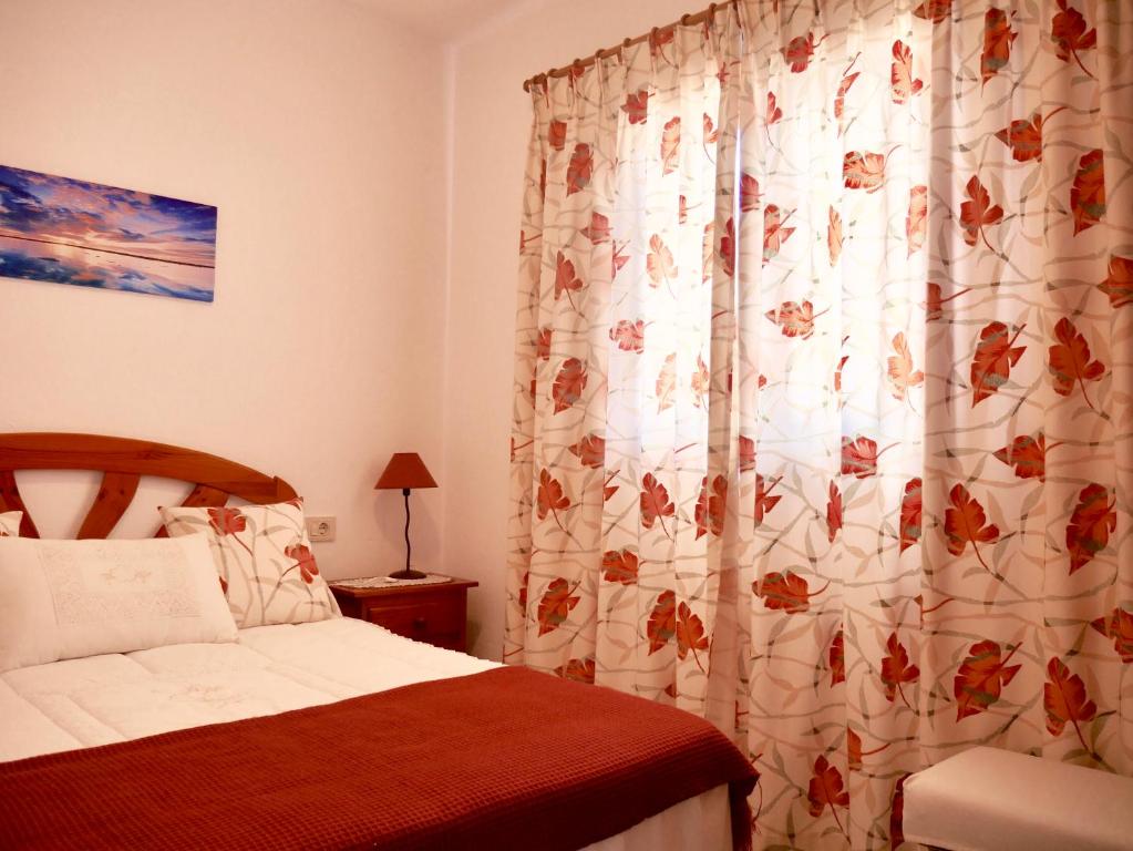um quarto com uma cama e uma cortina de chuveiro em Casa Suso & casa Margarita em Orzola
