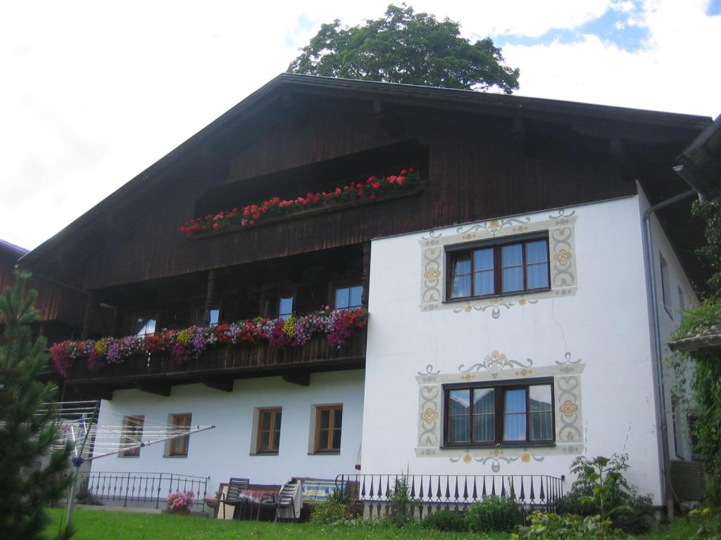 ein weißes Haus mit Blumen auf dem Balkon in der Unterkunft Klammer Gabi in Obertilliach