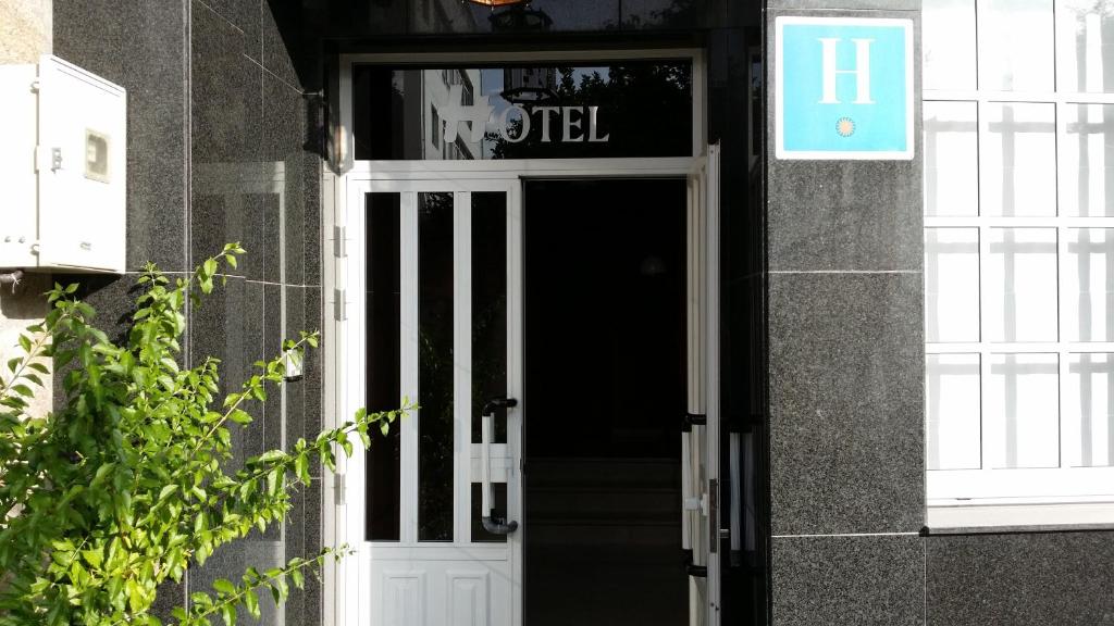 una porta per un edificio con un cartello sopra di Hotel Victorino a Silleda