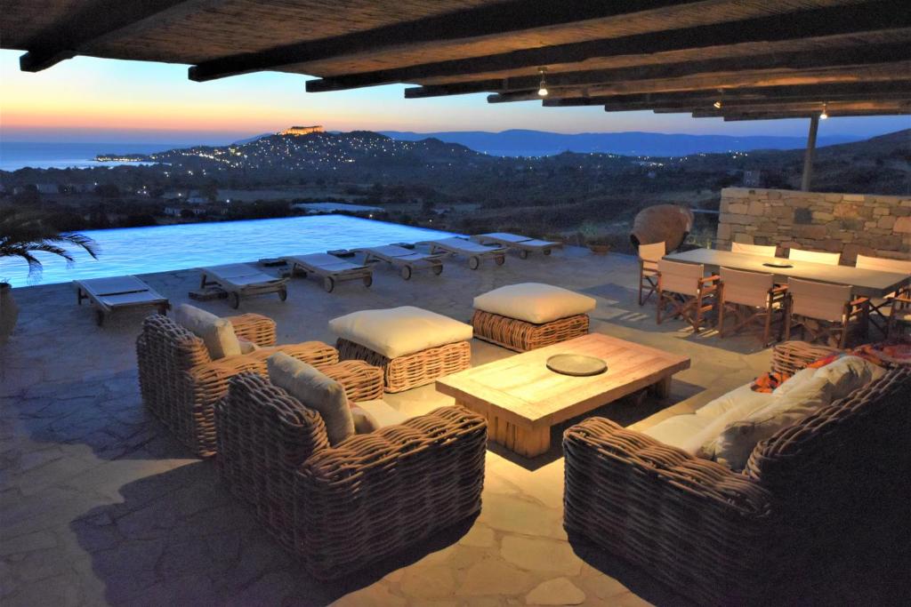 a patio with a table and chairs and a pool at Villa Molivos Views in Mythimna