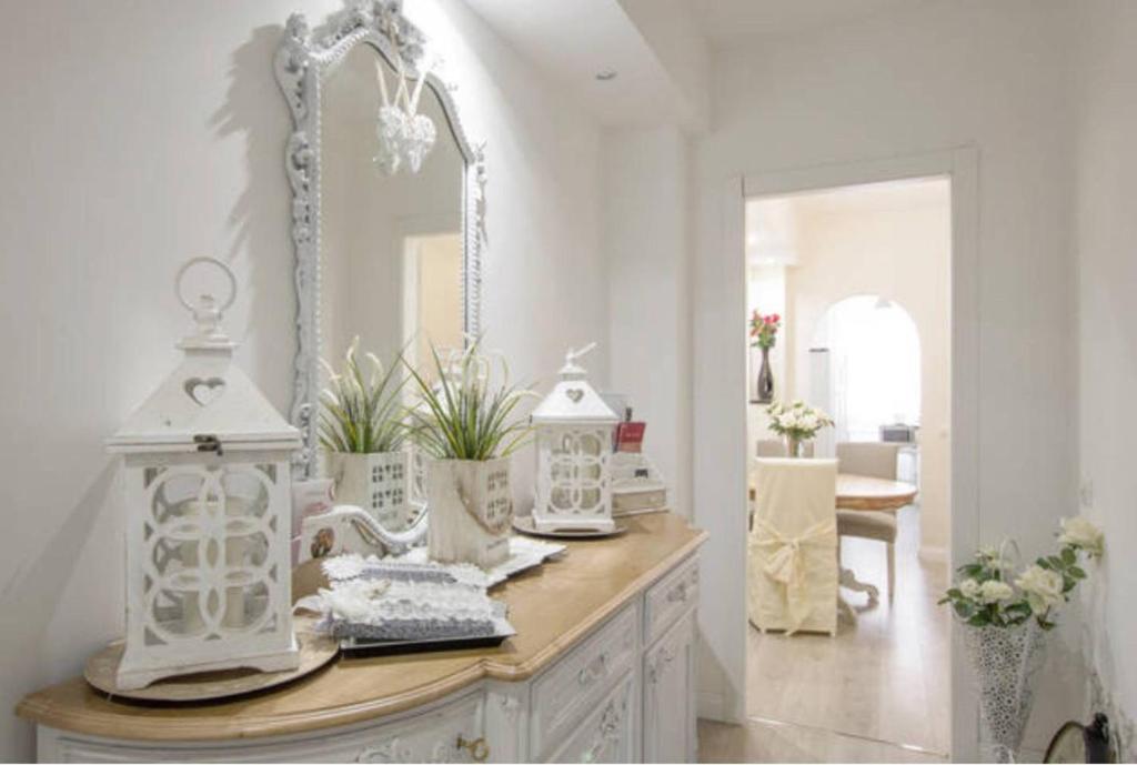 ローマにあるBorgo Pio 66 Suitesの鏡付きの洗面台とテーブルが備わる客室です。