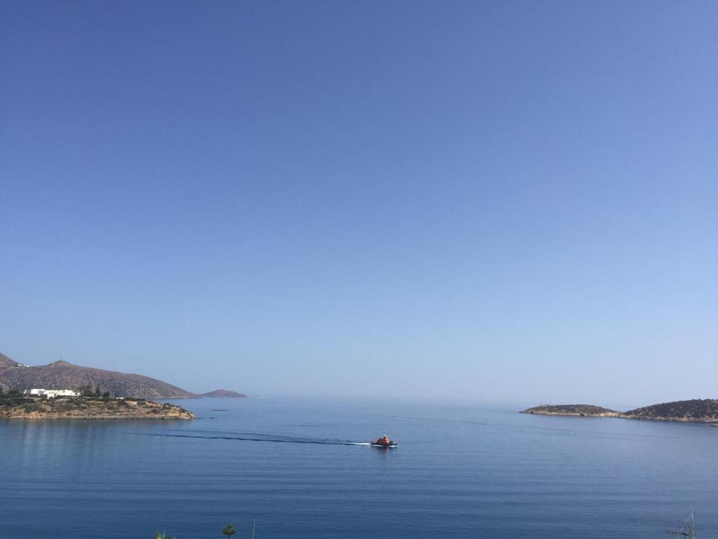 a boat in the middle of a large body of water at Big Blue Luxury Apartment in Agios Nikolaos