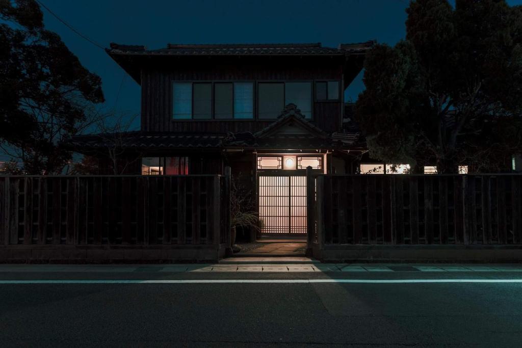 una casa con una puerta y una valla en Guest House Yonemuraya, en Matsue