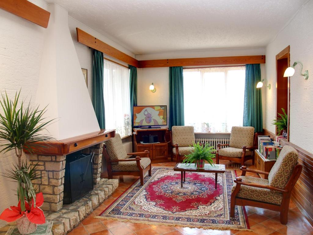 a living room with a fireplace and chairs at Hotel Garni Suisse in San Martino di Castrozza