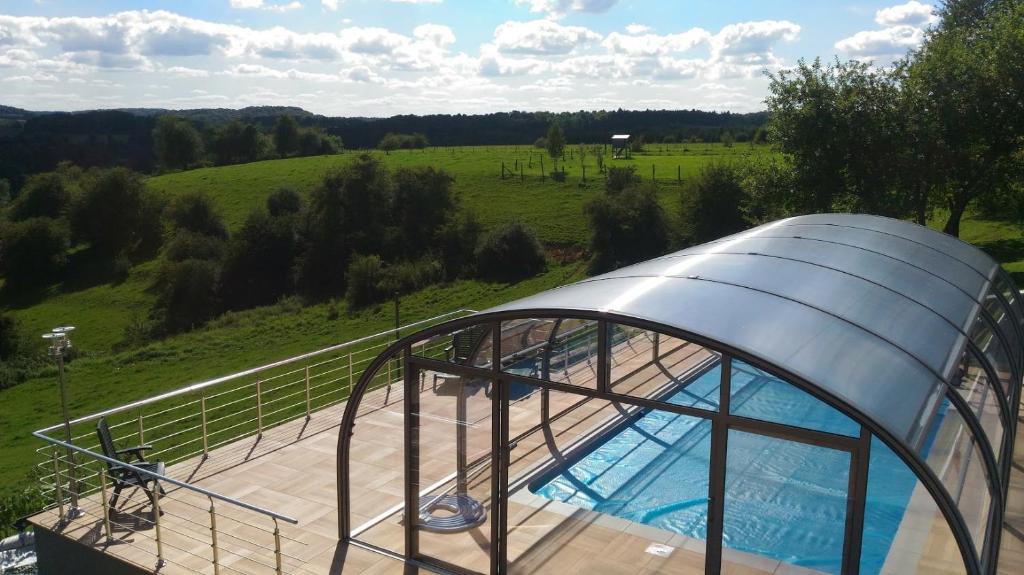 uma casa cúpula com uma piscina num campo em Gite des 3 bouleaux em Robelmont