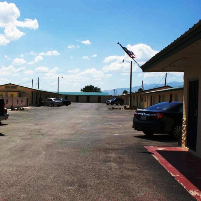 a parking lot with cars parked in front of a building at HWY Express Inn and Suites in Thatcher