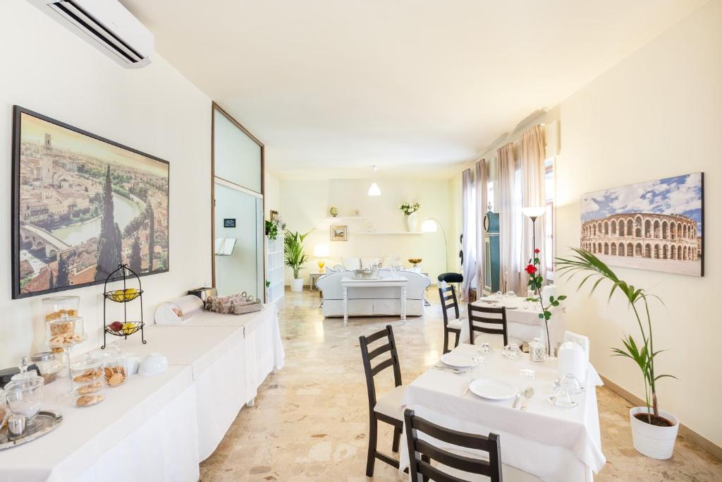 a dining room with white tables and chairs at B&B Happiness - City Center in Verona