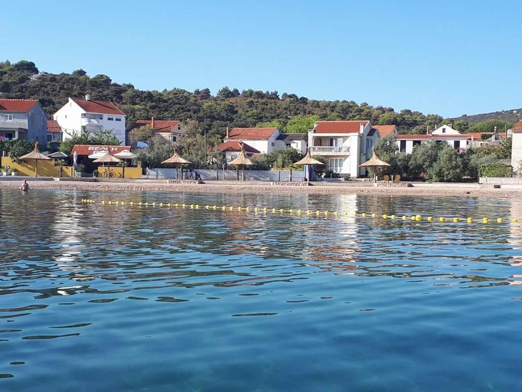 a view of a beach with houses and the water at Apartment Adria in Tkon