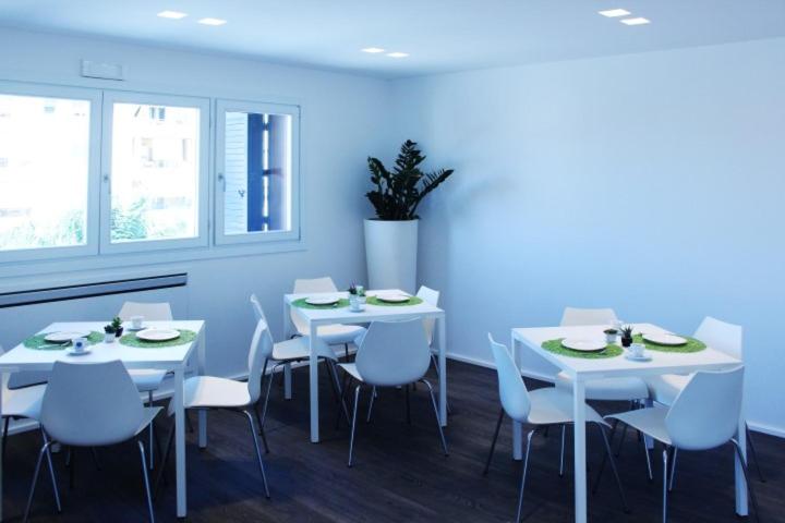 een eetkamer met witte tafels en witte stoelen bij Reggionord in Reggio di Calabria
