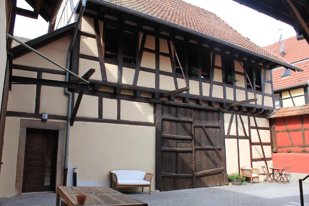 an old building with a wooden door and a table at Gîte de l&#39;ours grognon in Dambach-la-Ville