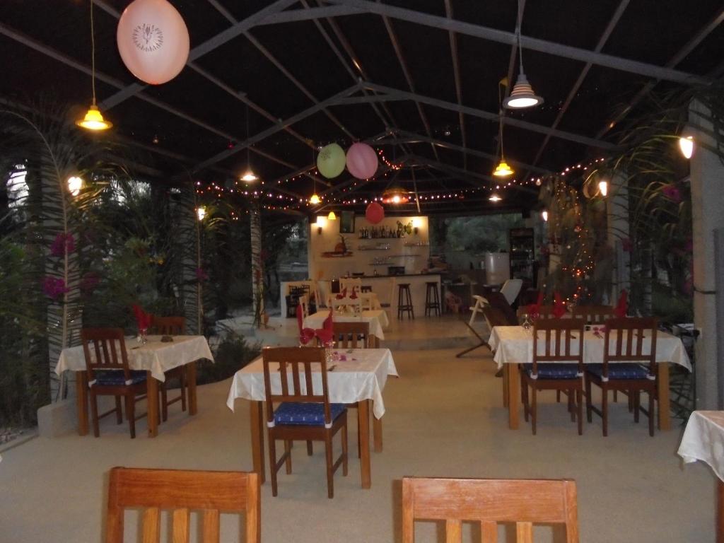 a restaurant with white tables and chairs and lights at Bolongs Passion in Cap Skirring