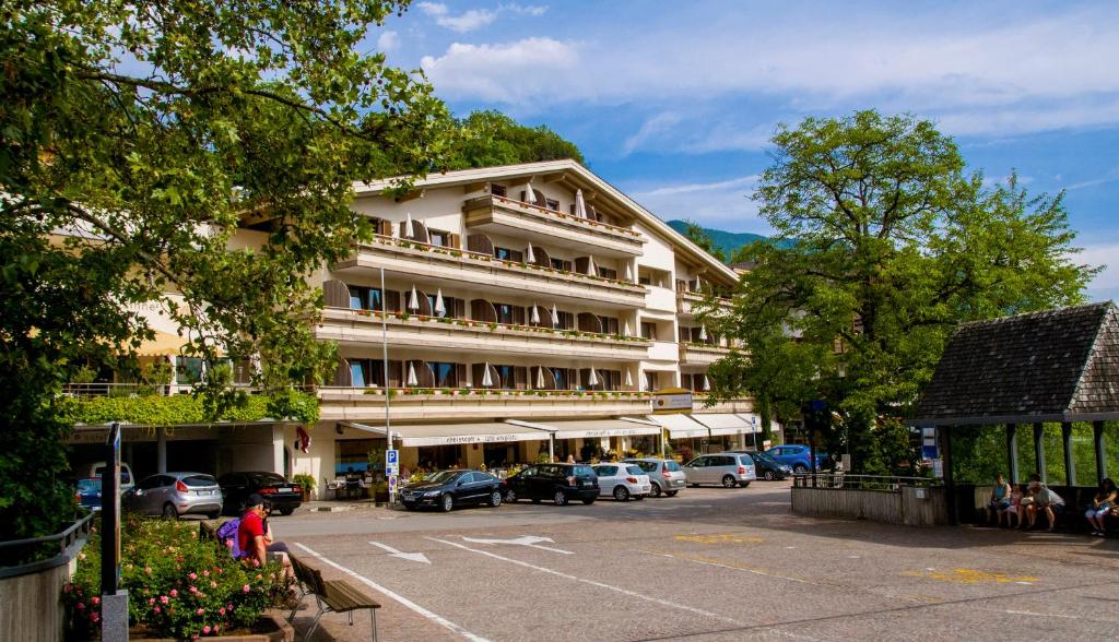 a large building with cars parked in a parking lot at Christophs Hotel in Schenna