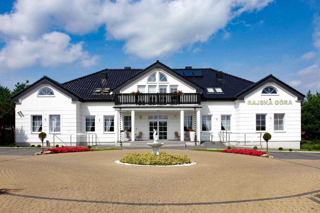 a large white building with a black roof at Dworek Rajska Góra in Wejherowo